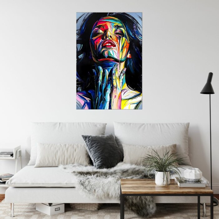 En un salón de color claro, encima de un sofá gris claro, vemos un moderno y colorido cuadro de una mujer.